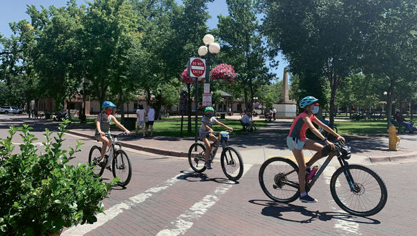 Cyclists circle a largely empty plaza in Santa Fe, which normally is bustling with tourists in the summer. Cyclists circle a largely empty plaza in Santa Fe, which normally is bustling with tourists in the summer.