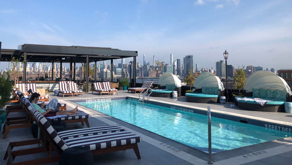 People on their laptops at the Williamsburg Hotel's rooftop pool. People on their laptops at the Williamsburg Hotel's rooftop pool.
