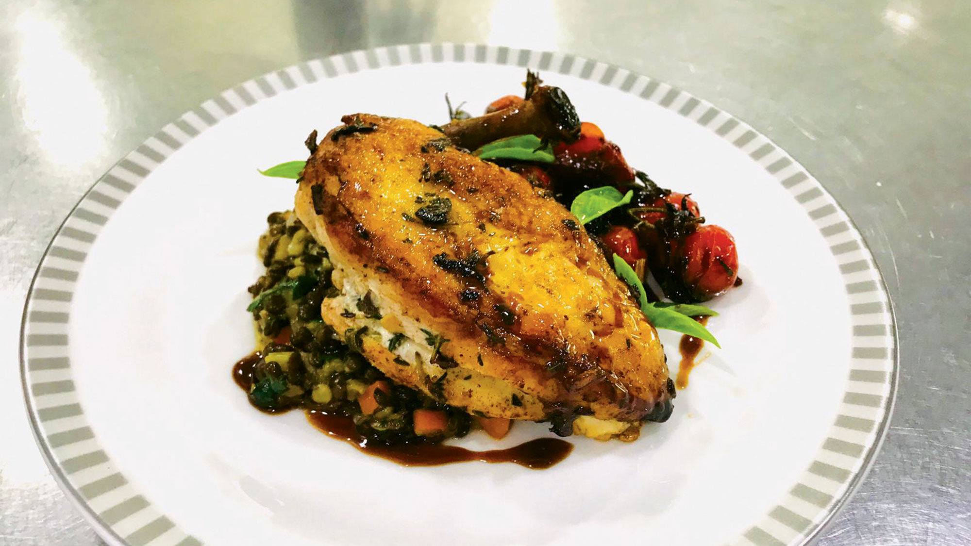 Singapore Airlines' herb-roasted chicken breast, black beluga lentils and roasted, caramelized tomatoes, plated by the carrier's food and beverage director Antony McNeil.