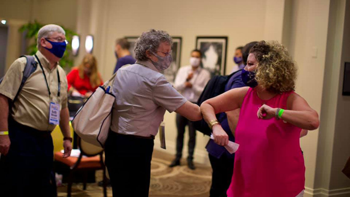 Jenn Lee bumps elbows with an attendees at Travel Planners International’s recent in-person event, the Rockstar Rendezvous.