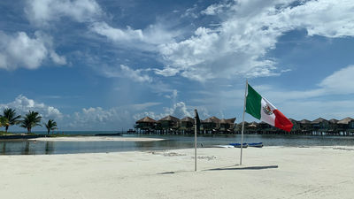 A Mexico flag planted on the beach of the El Dorado Maroma resort in Riviera Maya, Mexico, in October.