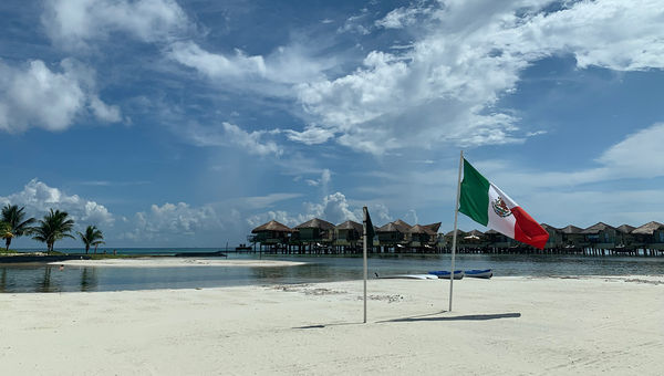 The Mexcan flag planted on the beach of the El Dorado Maroma in Riviera Maya. The Mexcan flag planted on the beach of the El Dorado Maroma in Riviera Maya.