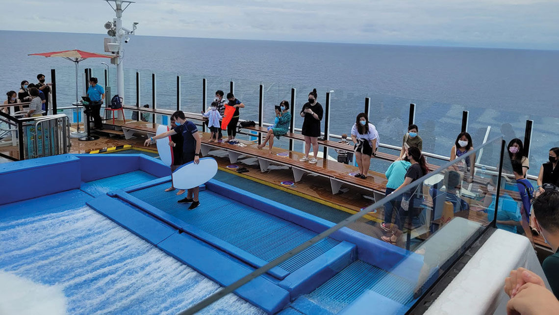 Passengers on the Quantum of the Seas' first sailing, masked and distanced near the aft Flow Rider.