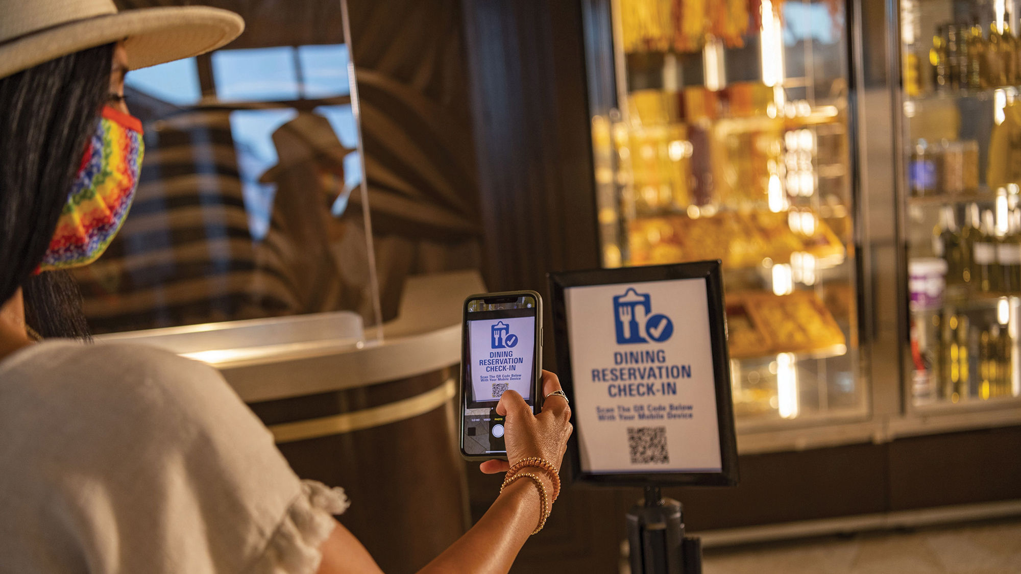 A Disney World guest using a cellphone to check in at a table-service restaurant.