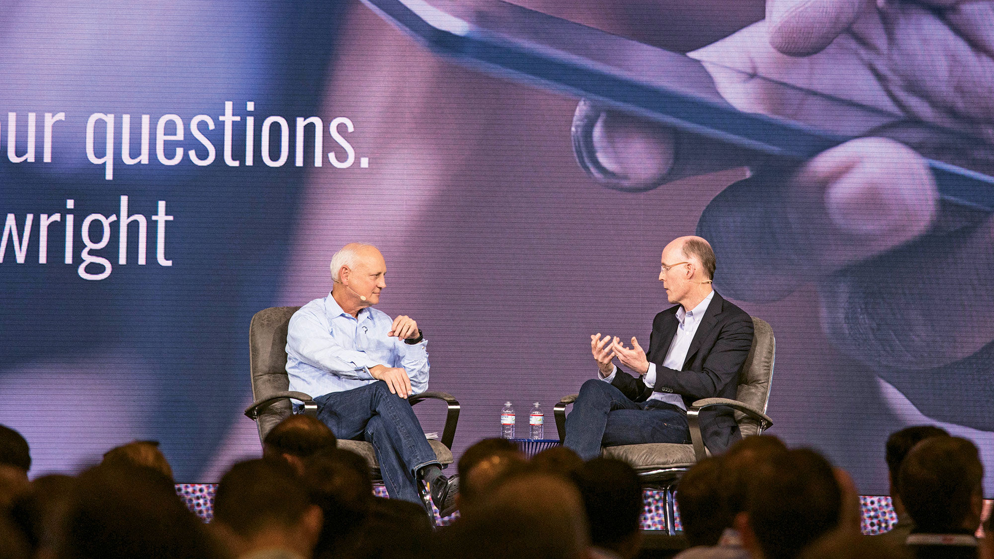 Philip Wolf, left, the founder of Phocuswright, with Richard Holden, the vice president of product management for Google, at the 2018 Phocuswright Conference's Center Stage. Wolf, the founder of Phocuswright, died on Tuesday