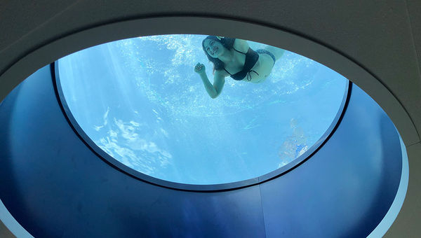 An oculus at the bottom of the second-story pool offers swimmers a view of the hotel lobby.