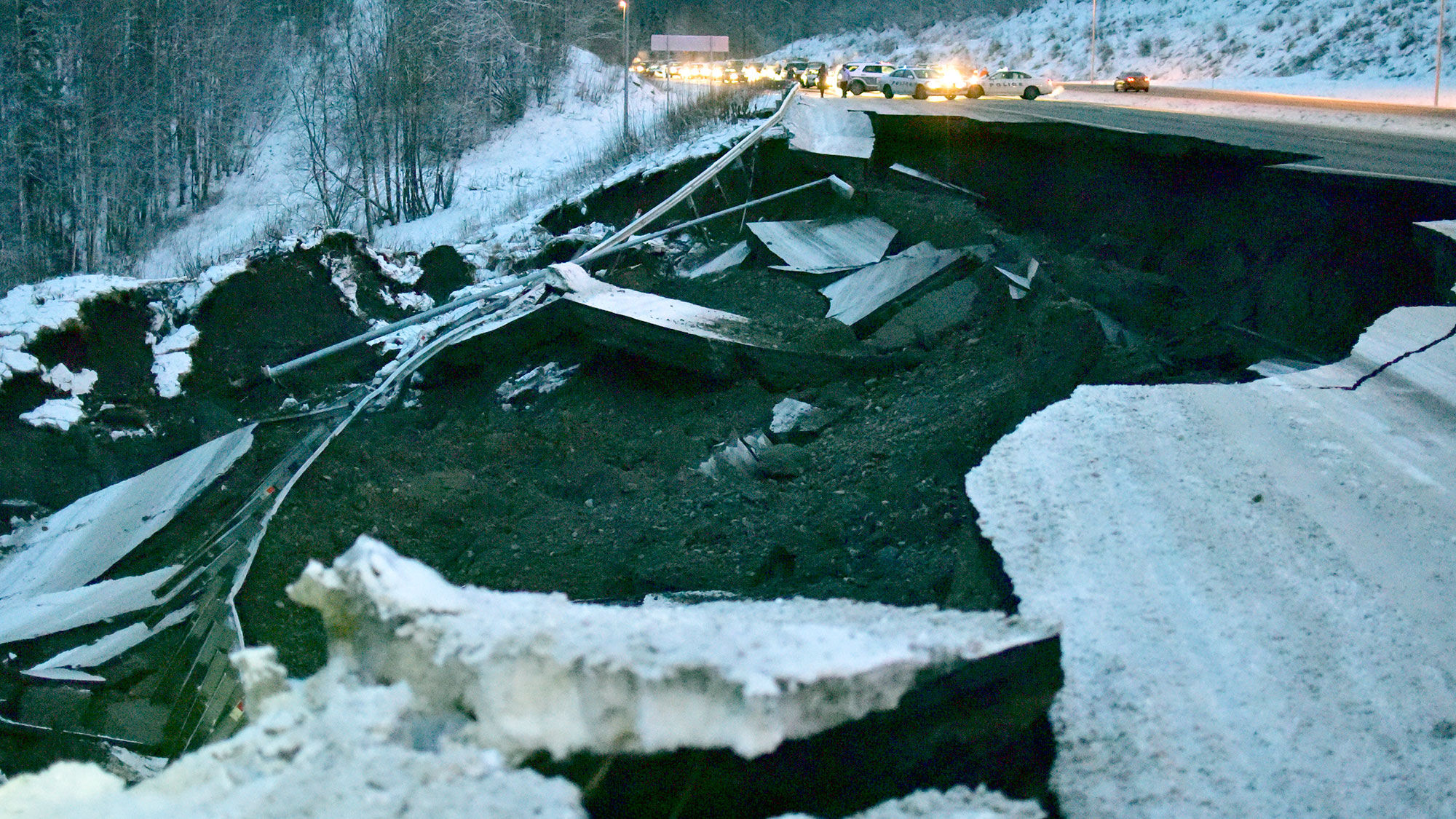 Police block traffic on the southbound Glenn Highway north of Anchorage, due to earthquake damage.