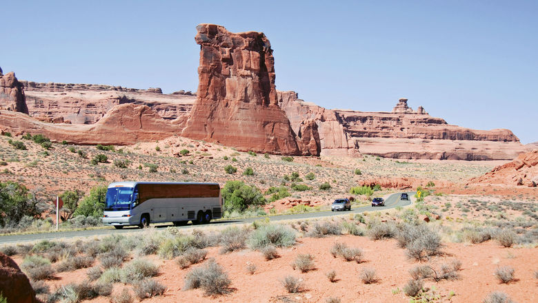 A motorcoach tour rolls through Arches National Park in Utah.