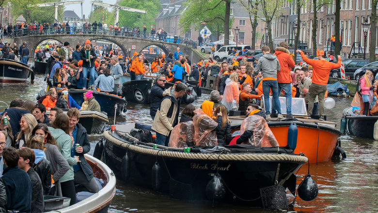 A crowded canal on King's Day in Amsterdam.