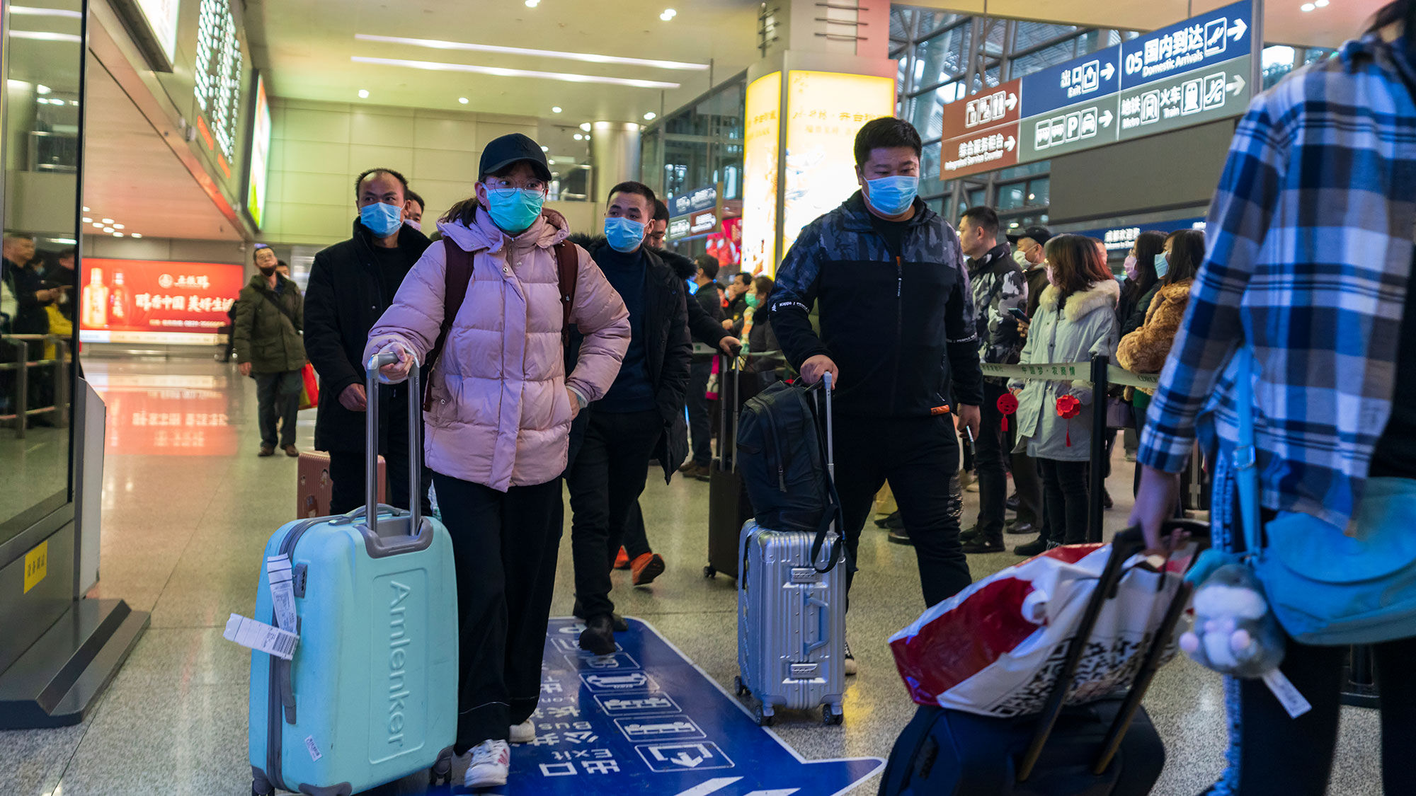 Travelers at Chengdu's airport wearing masks.