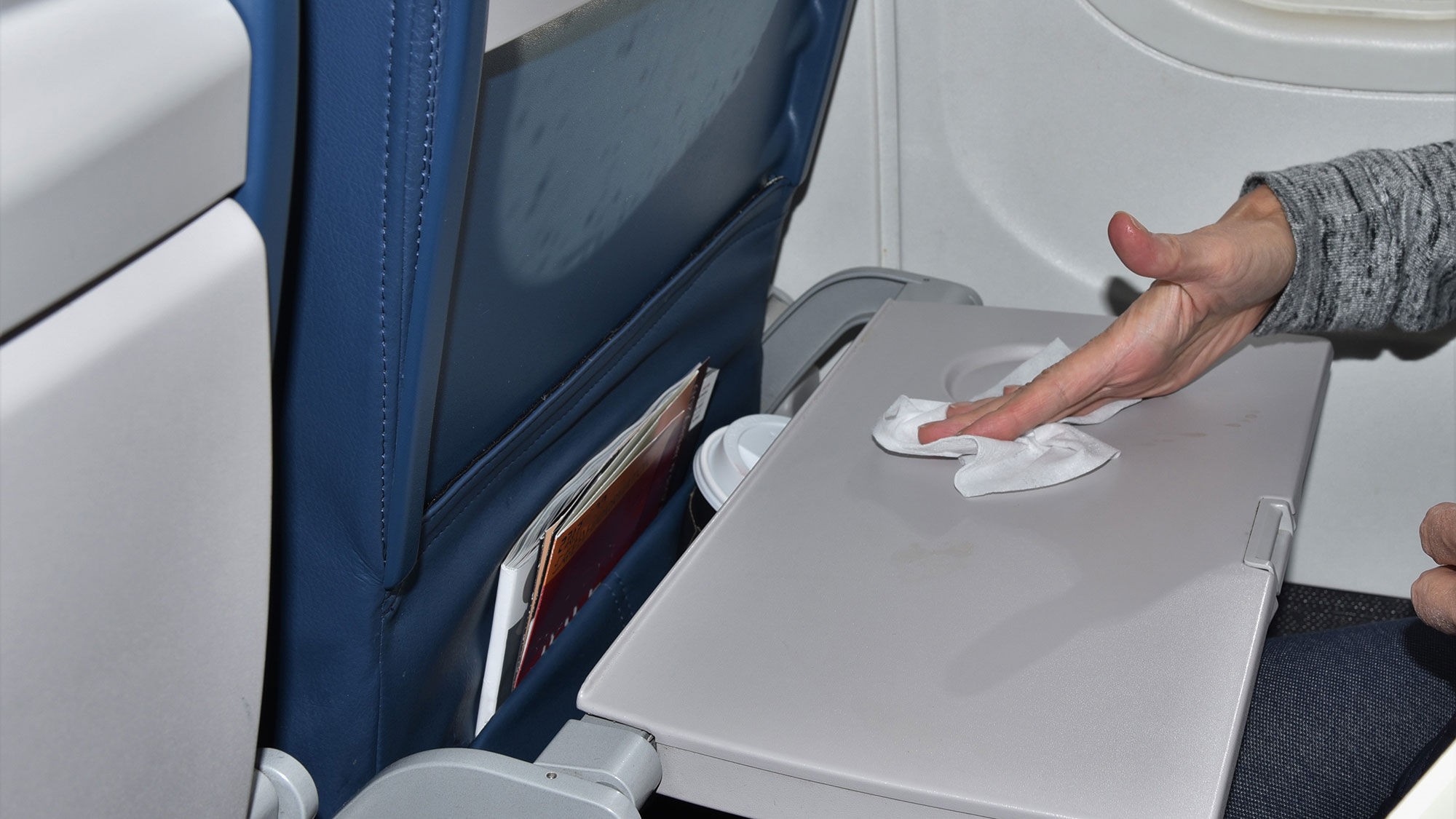 After taking your seat, cleaning the tray table with sanitary wipes is a good idea.