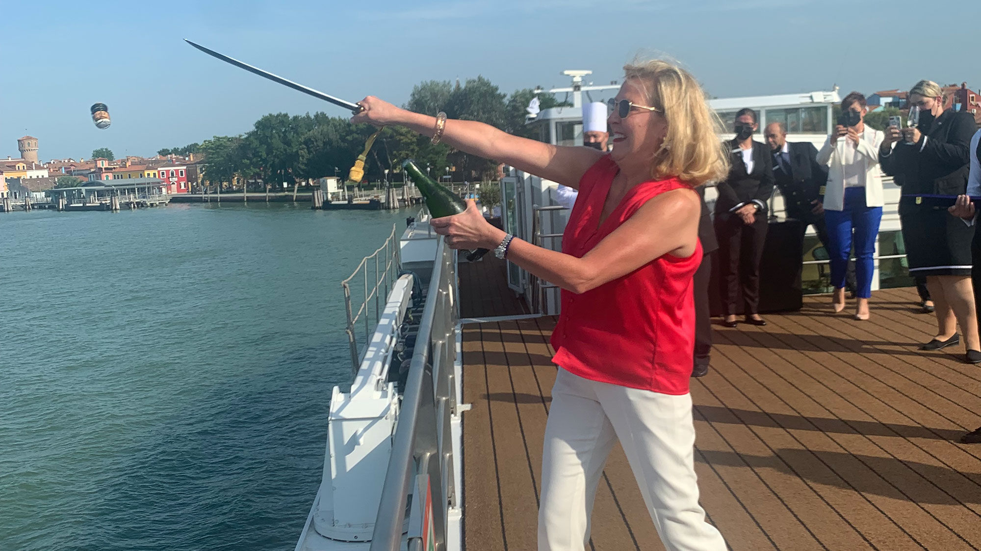 Uniworld Boutique River Cruises' CEO sabers the top of a champagne bottle to celebrate the renaming of the S.S. La Venezia.