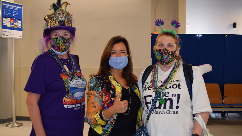 Carnival president Christine Duffy (center) and two guests wearing face coverings on the new Mardi Gras cruise ship.