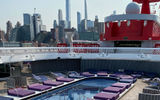 The Scarlet Lady's pool deck with the New York skyline in the background.