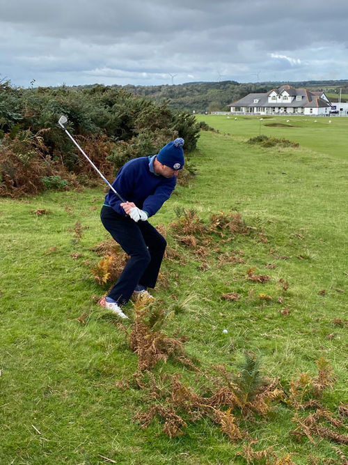 On the 18th hole at Southerndown, Robert Silk tries to hit his ball from a precarious lie.