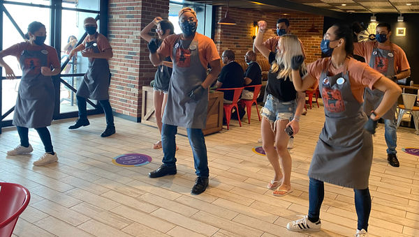 Staff and guests line dancing at Portside BBQ.