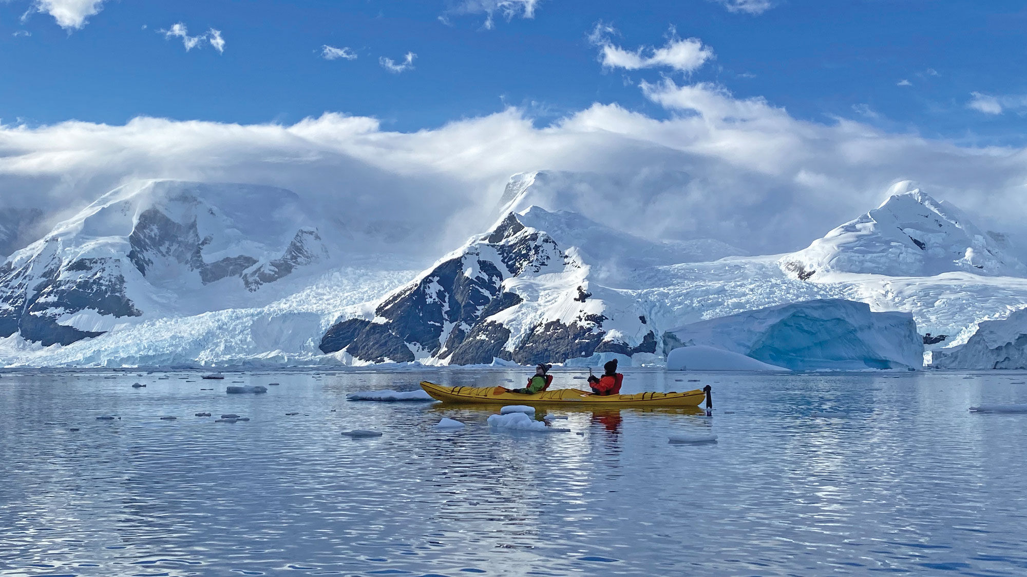 A mother-son duo kayaks amid floating ice during a brilliant morning in the Andvord Bay.  Kayaking and stand-up paddle boarding are both offered on the Eclipse during every excursion block, weather permitting.