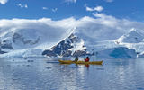 A mother-son duo kayaks amid floating ice during a brilliant morning in the Andvord Bay.  Kayaking and stand-up paddle boarding are both offered on the Eclipse during every excursion block, weather permitting.
