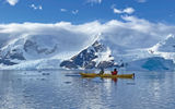 A mother-son duo kayaks amid floating ice during a brilliant morning in the Andvord Bay.  Kayaking and stand-up paddle boarding are both offered on the Eclipse during every excursion block, weather permitting.