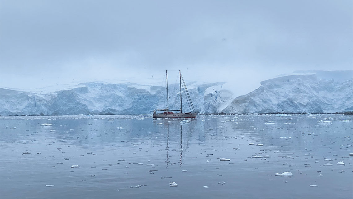 At the Antarctic Peninsula's Jougla Point, a sailboat anchored amid an ice-world creates a scene fit for a blockbuster adventure film.