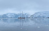 At the Antarctic Peninsula's Jougla Point, a sailboat anchored amid an ice-world creates a scene fit for a blockbuster adventure film.