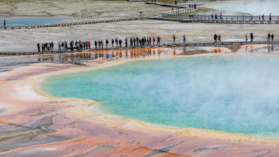 Visitors stand on the boardwalk near the Grand Prismatic Spring in Yellowstone National Park.