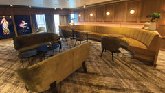 What attracts a cruiser to the Atlas Bar on the Azamara Onward? Perhaps the hushed golden hues of the curved couches and the comforting thick olive curtains draping the windows.