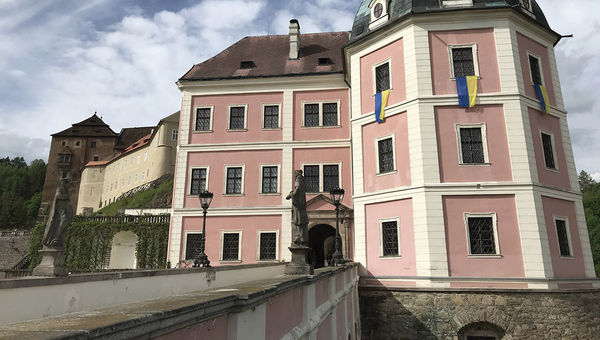 Becov castle complex with Ukrainian flags on display.