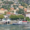 A public ferry sails Lake Como with a hillside view of the luxury lakeside city in the background.