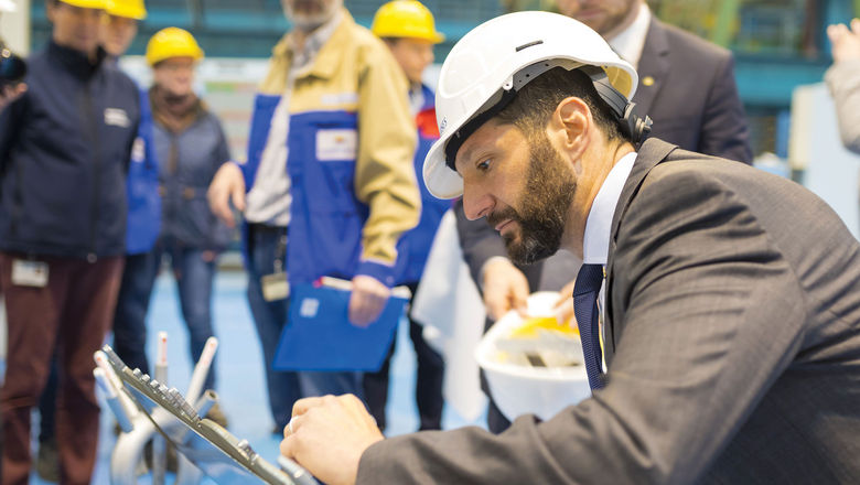 Josh Weinstein, at the time the president of Carnival UK, signs a silhouette of the P&O Cruises ship Iona at its steel-cutting ceremony in 2018.