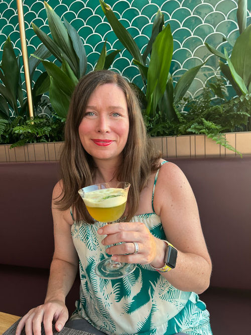 The hat-trick: The author, holding a cocktail, in Eden, at sunset.