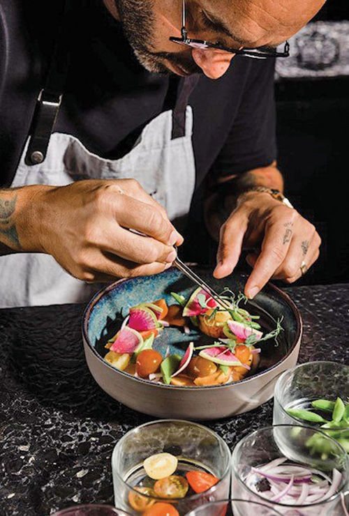 A chef prepares a salad at Rooster and the Till, a restaurant in Tampa listed in the new guide.