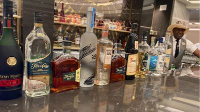 Bartender Clarence Bennett displays liquors at the Metropolitan Bar on the Norwegian Prima.