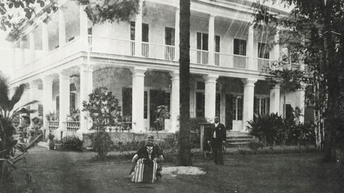 Queen Liliuokalani sits outside Washington Place, which was her home from 1862 to 1917.