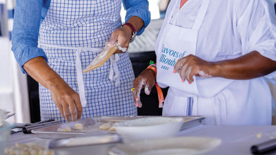 Chef Nina Compton, in blue shirt, helps the writer wield a gnocchi board.