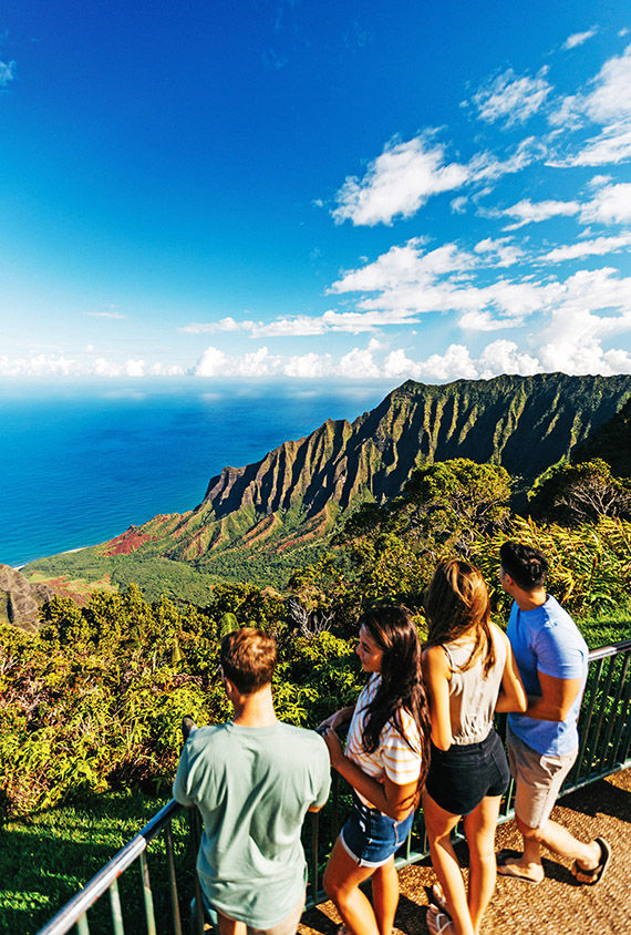 People enjoy the breathtaking view from Kalalau Lookout on Kauai.