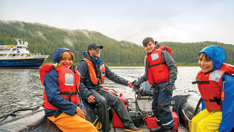 Children learn to drive a Zodiac in Alaska on a Lindblad Expedition-National Geographic sailing, as part of the Global Explorers program.