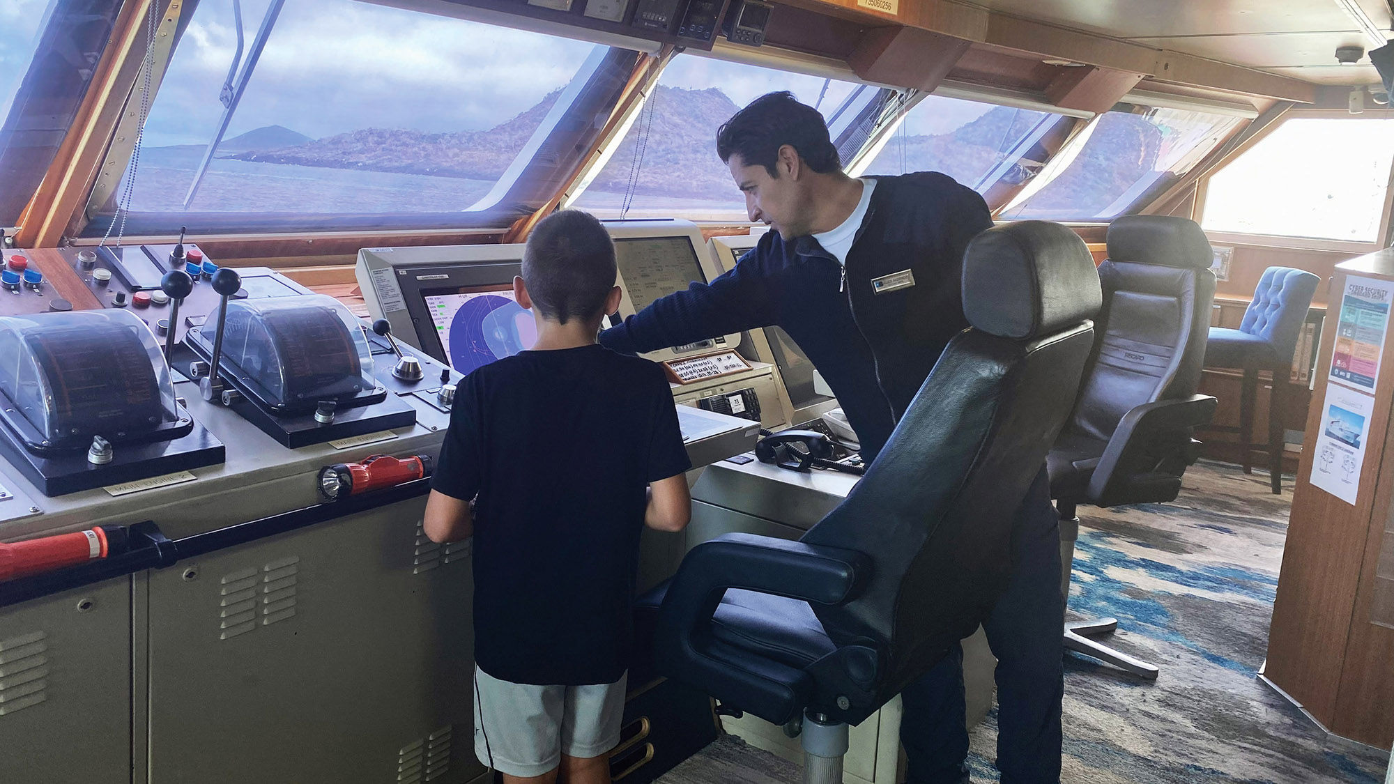The author's son gets a lesson on the bridge on Lindblad Expeditions' National Geographic Islander II.