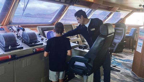 The author's son gets a lesson on the bridge on Lindblad Expeditions' National Geographic Islander II. The author's son gets a lesson on the bridge on Lindblad Expeditions' National Geographic Islander II.