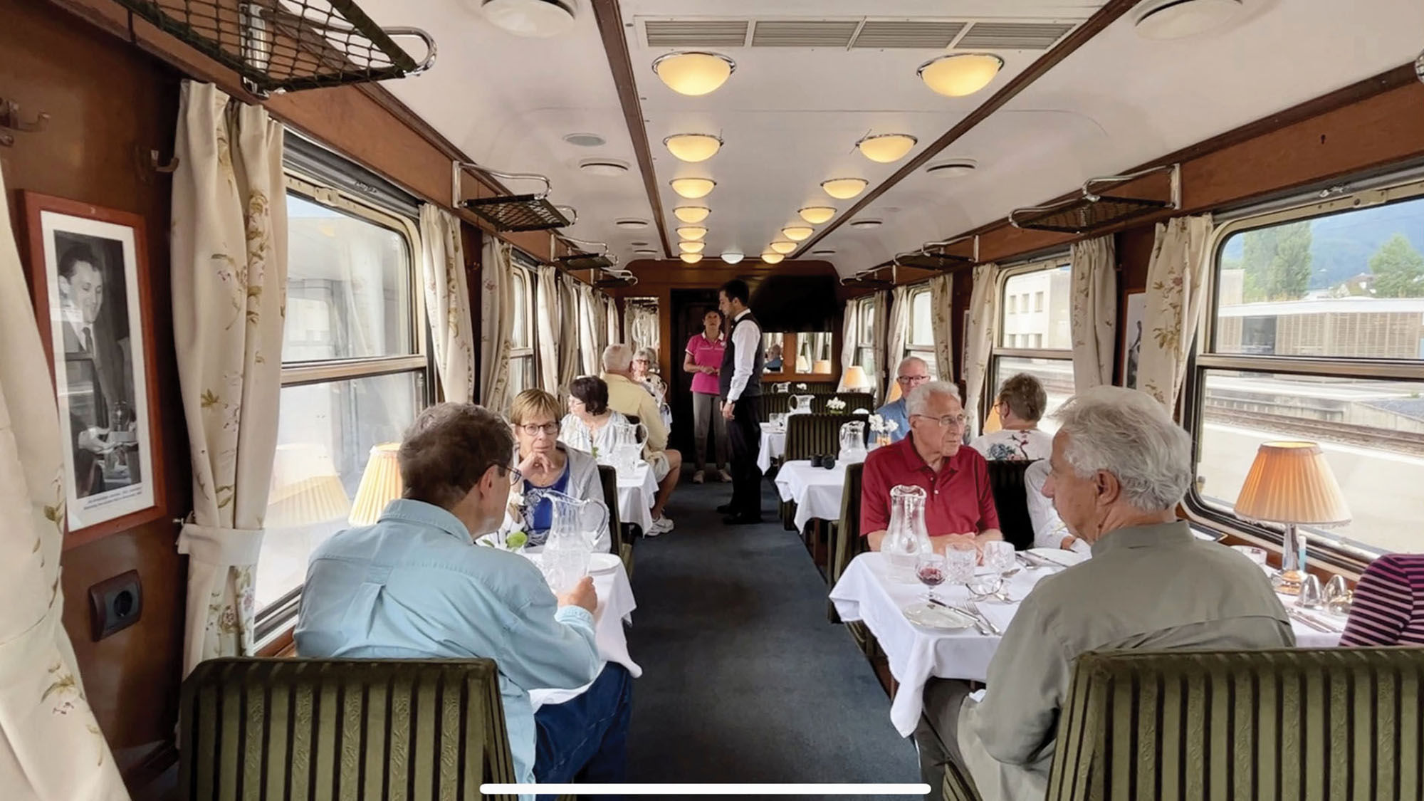 Passengers enjoy a meal in the dining car.