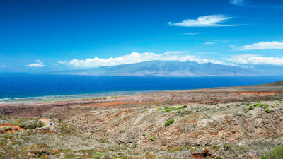 A view of Lanai's Shipwreck Beach coastline with the island of Molokai in the distance.