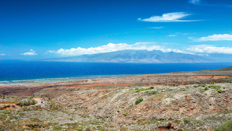 A view of Lanai's Shipwreck Beach coastline with the island of Molokai in the distance.