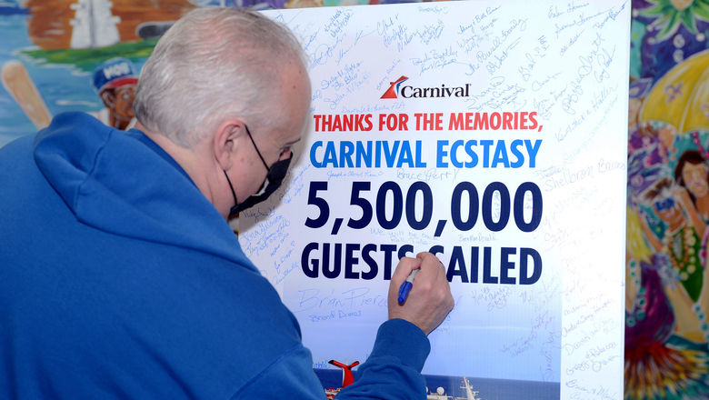 Carnival brand ambassador John Heald signs Carnival Ecstasy farewell poster.