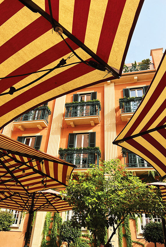 The cheerful tan-and-red umbrellas in the courtyard of Rocco Forte Hotels' Hotel de la Ville in Rome.