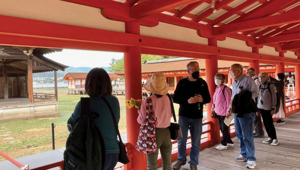 Visitors with an Alexander + Roberts tour group explore the Itsukushima Shinto shrine in Miyajima, Japan.