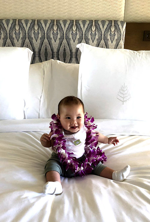 The writer's infant daughter with a lei.