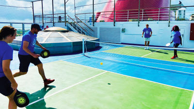 Crew members on the Carnival Conquest play pickleball on the ship's new court.