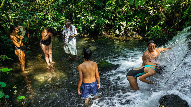 Sumpa, a shaman elder from the village of Wachirpas, conducts a cleansing ritual for a family at a hidden waterfall.