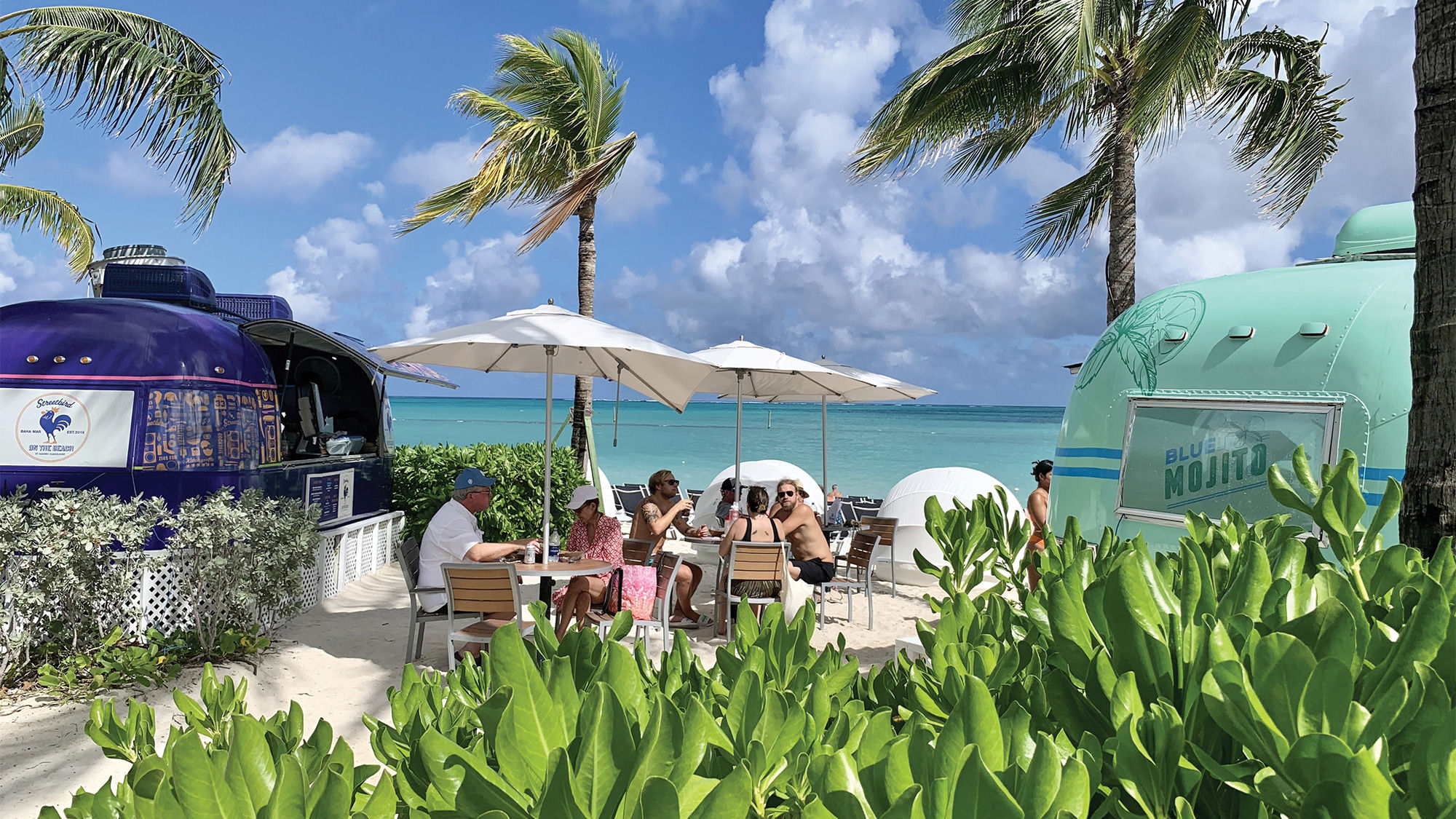 Food and drink trucks are parked right off the beach.