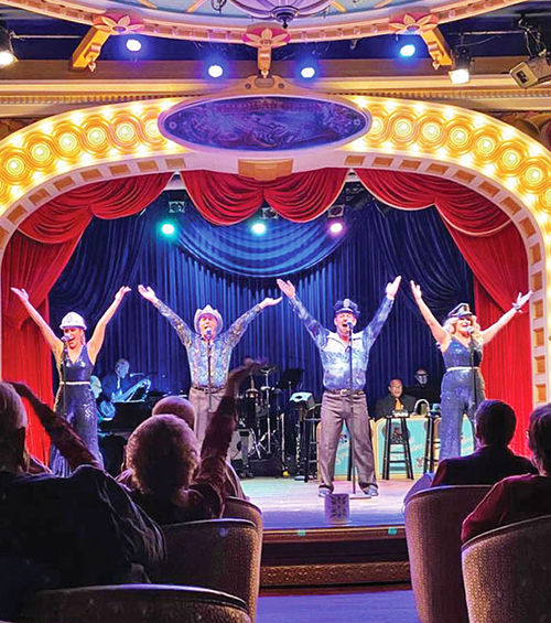 The American Queen's four-member entertainment team, led by cruise director Alex Bernhardt, third from left, perform during a 1970s tribute show in the ship's Grand Saloon.
